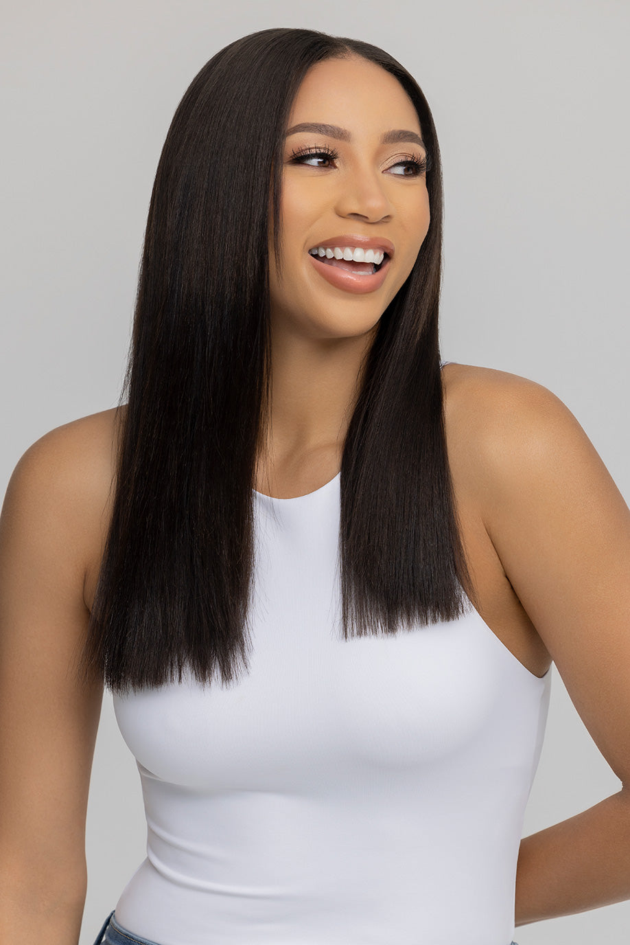 Smiling woman with long straight hair wearing a white tank top.