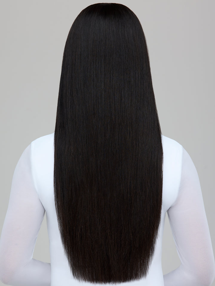 A person shown from the back wearing a long, straight black wig or hair extension against a plain light gray background.