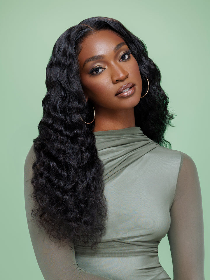 Close-up of Black woman with long black wavy hair and sage green mesh top